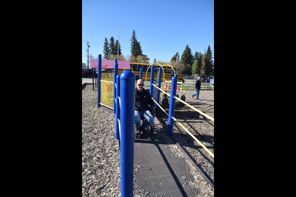 Barrhead Regional Fire Services firefighter Jonathan Hynes tests how accessible the elementary school's adventure playground is.