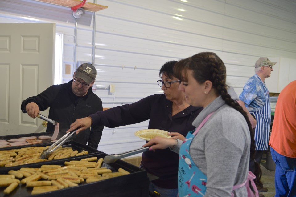 From left: Kelvin Fott, Vanessa Pearson, and Madonna Larson draw meat cooking duty.