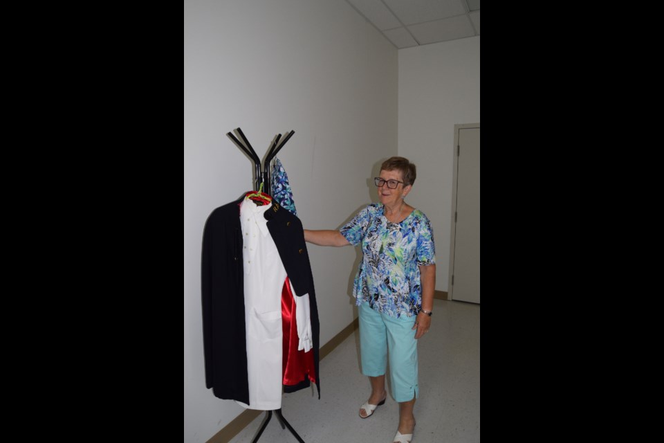 Linda Klufas celebrated her 50 years in nursing during a retirement party at the Barrhead Seniors' Drop-in Centre on the afternoon of Saturday, Oct. 1. Klufas, pictured here, next to her first uniform, which she said was more of a dress uniform that included a cape.
