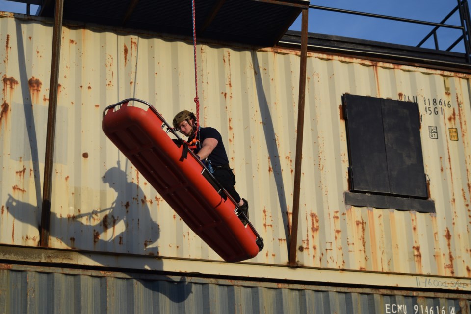 BRFS firefighter Kyle Merrell midway down the fire department's sea-can apartment village during a rappelling demonstration. 