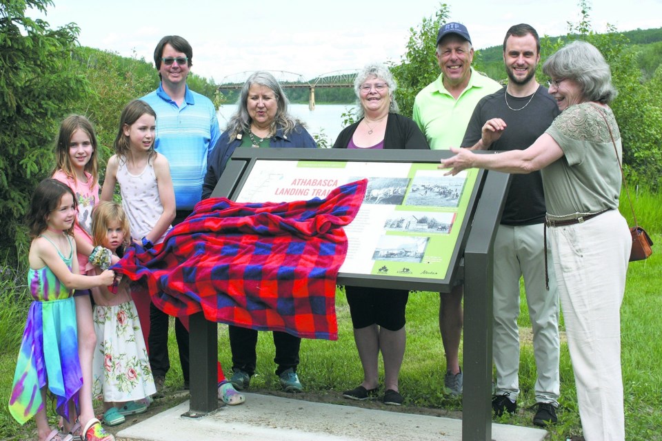Town officials and members of the public gathered at the confluence of the Athabasca and Tawatinaw rivers June 22 to unveil a new sign to commemorate the importance of the Athabasca Landing Trail to the development of northern Alberta in the late 19th Century. The small gathering, complete with coffee and cookies, enjoyed a pretty decent view for the unveiling. Pictured, L-R, sisters Charlotte, Addy, Jacklynn and Isabelle Whalen joined Michael Borody, Coun. Ida Edwards, Coun. Edie Yuill, mayor Rob Balay, Coun. Jon LeMessurier and local archivist and historical society member Margaret Anderson.