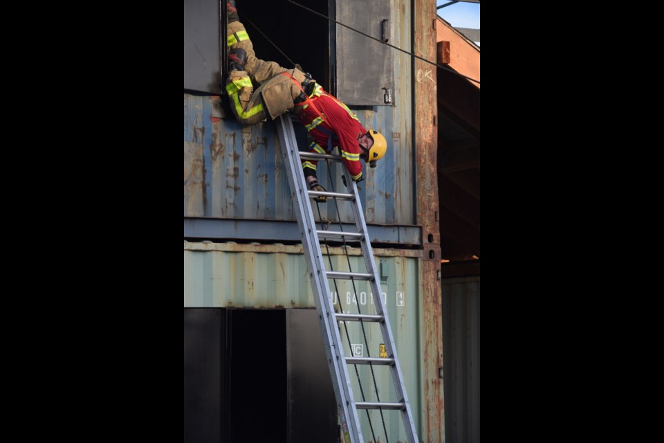 BRFS firefighter demonstrates the correct technique of exiting a burning building from a second-story window by starting head first. 