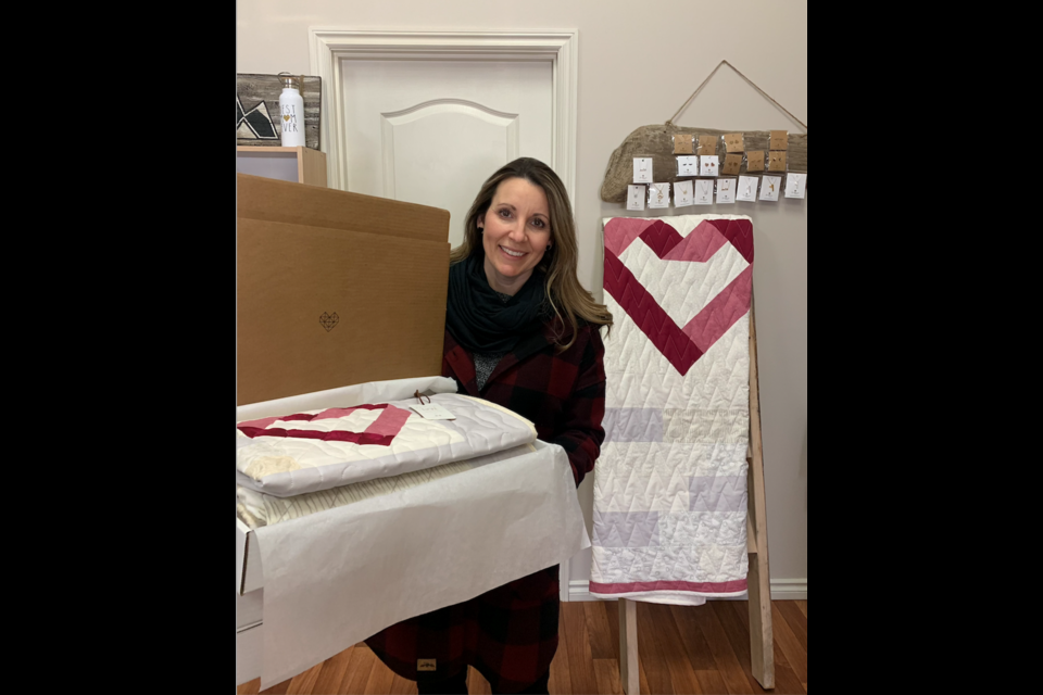 Michelle Madson poses with some of the homemade quilts she has donated to cancer patients as part of a project she runs alongside her custom apparel business in the Westlock area.