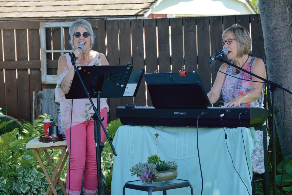 Julia Walker  and Sandi Johnston perform a song as part of the Sweet Harmony Duo, during an afternoon backyard session of Music in the Park on Aug. 14. 