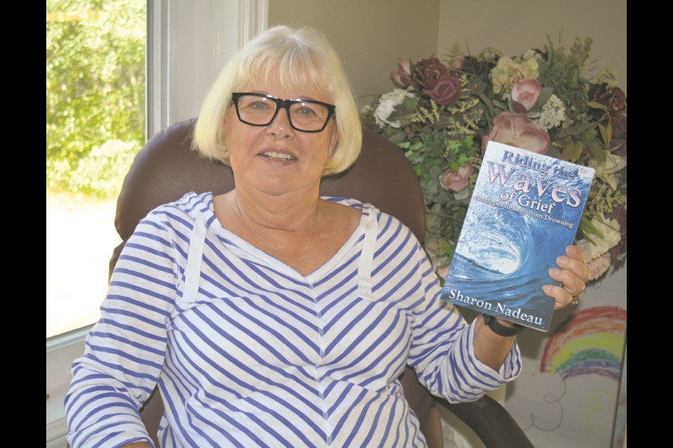 Author Sharon Nadeau holds up her most recent book, published in December 2021. The book, entitled Riding the Waves of Grief: Strategies to Keep from Drowning is a self-help, step-by-step publication written from personal and professional experience and aims to help others how to deal with grief, heal and move forward.