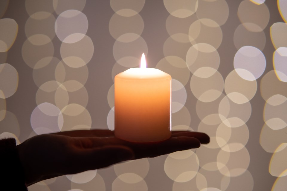 in-memoriam-single-candle-on-palm-of-hand