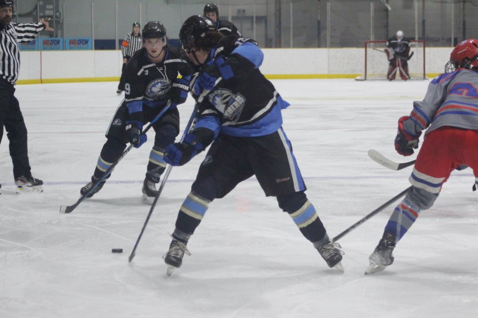 Barrhead Bomber Austin Galway takes a look behind him before passing the puck to teammate Christopher Vinck as they enter the Stavely Mustangs zone in an Oct. 13 home game.