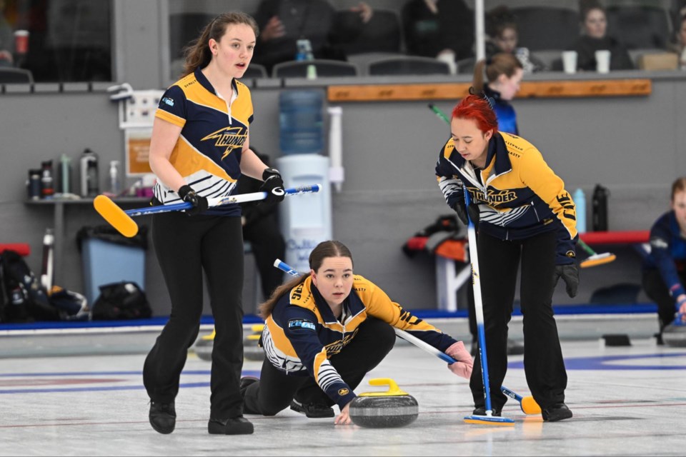  Barrhead’s Payton Sonnenberg throws a rock for the Concordial Thunder at the CCAA Women’s Championship in Fredericton, NB.  Lead Rachel Jost is on the left, and second Brenna Bilassy is on the right.