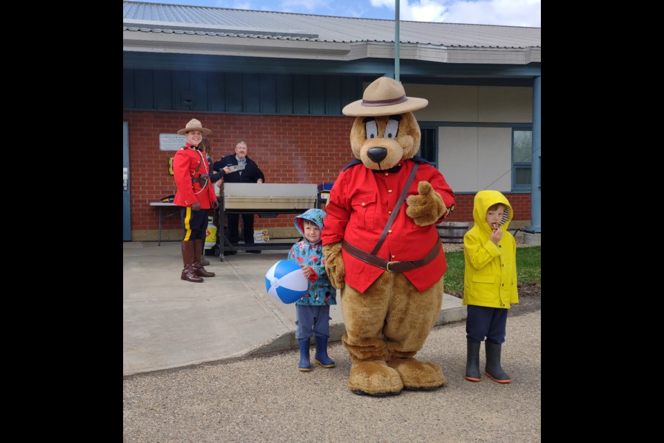Athabasca RCMP held a free barbeque for the community May 19, offering burgers, hotdogs and drinks as a way to reach out to the community as part of National Police Week. Being more visible and getting out into the community is one of the priorities the detachment will be working on for the coming year. Pictured, Safety Bear with brothers Austin (left) and Owen Chaput, who dropped by with mom and dad for a bite. Const. Jay Tessier, in Red Serge for the event is to the left, and Cpl. Alan Caldwell mans the grill. 