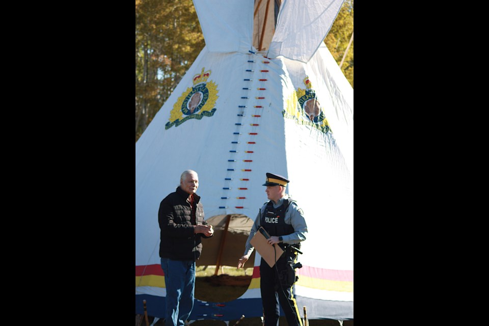 The Athabasca RCMP Detachment held its first Indigenous Culture Day at the detachment Sept. 22, transforming the detachment parking lot and green space into an opportunity to bring communities together, learn about local Indigenous culture and network with their neighbours and friends. Local detachment members, ‘K’ Division brass, students and members of the Bigstone Cree Nation, including elder Victor Gladue, marked the day with a pipe ceremony inside the RCMP teepee, which was set up on the grounds, especially for the day, along with a display from the Calling Lake Historical Society, and an RCMP vehicle students were allowed to decorate with water soluble paint. Pictured, Elder Victor Gladue, along with Const. Kyle Hotchkiss, who MC’d the event, just before 20 or more people gathered in the teepee to take part in a pipe ceremony led by Gladue, who accepted an offering of tobacco to conduct the ceremony. Pipe ceremonies are sacred events where an Elder offers prayers and ignites tobacco in the pipe which is then passed around the circle so each can either touch or smoke from the pipe. 

 