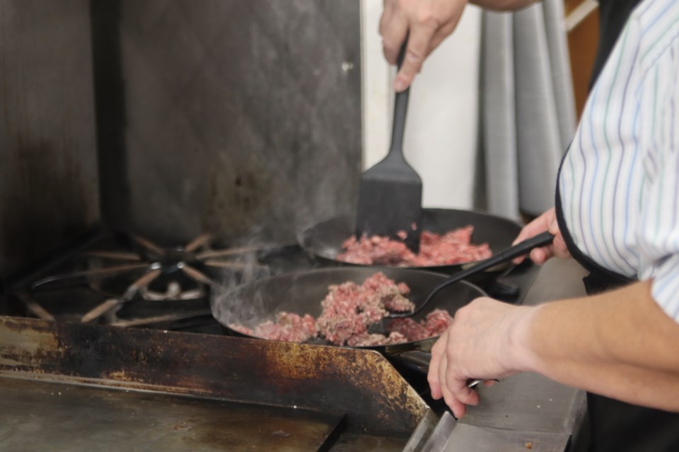 Participants in the FCSS Help at Home program for seniors cook the beef for the ground beef sliders meal prep at Vimy Community Hall on June 18.