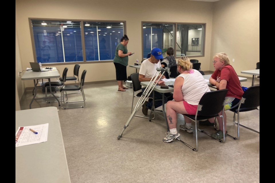 People fill out application forms at the Metis Nation of Alberta registry drive at the Westlock Rotary Spirit Centre on July 31.