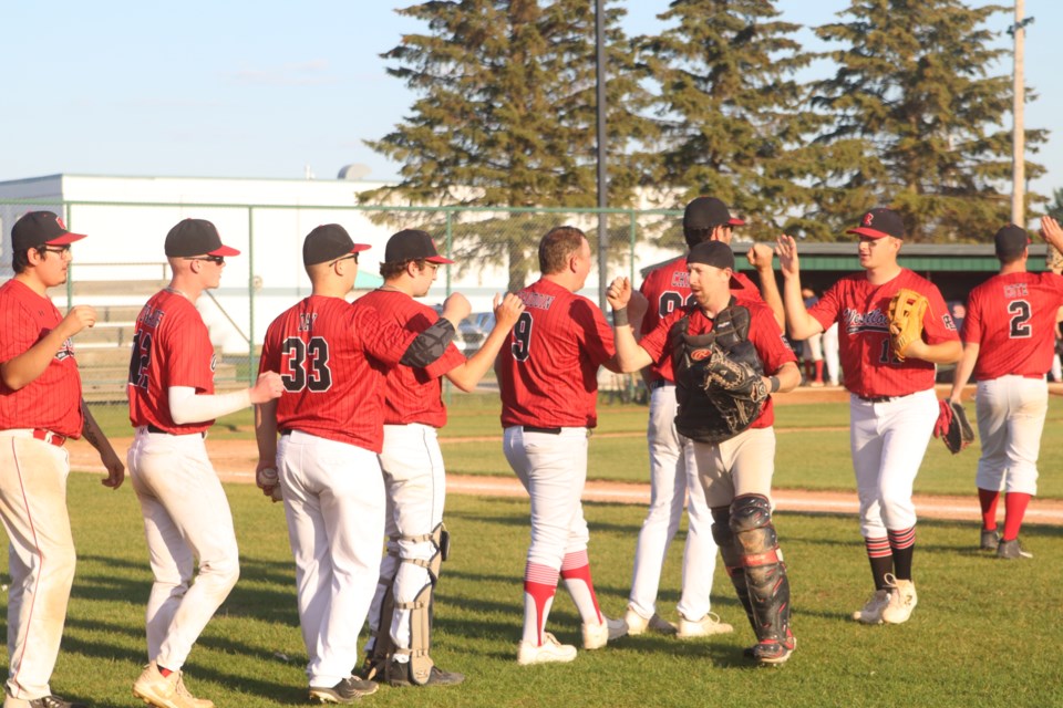 Red Lions' general manager and catcher Jordan Brand congratulates the team for keeping the Parkland Twins off the scoreboard in game one of the NCABL finals on Aug. 22. The Red Lions secured the NCABL title with a 2-0 series victory against the Twins with a 7-0 win in Westlock and 9-1 win in Spruce Grove.