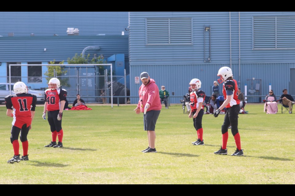 Coach Jared DeJong (centre) gives instructions to his team.