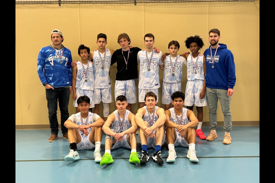 An exhausted St. Mary Sharks senior boys' basketball squad gathers together for a group picture after winning silver at the 1A North Central Zones, which were held March 8-9 at the Westlock Rotary Spirit Centre.