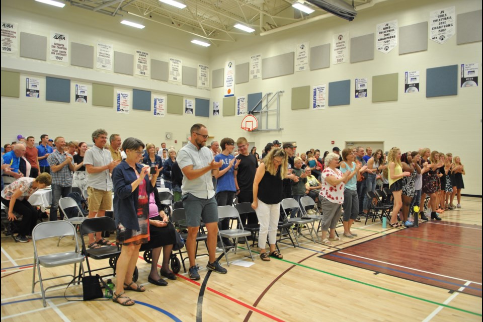 The attendees at Howard Gelderman's school retirement recognition event give him a standing ovation.