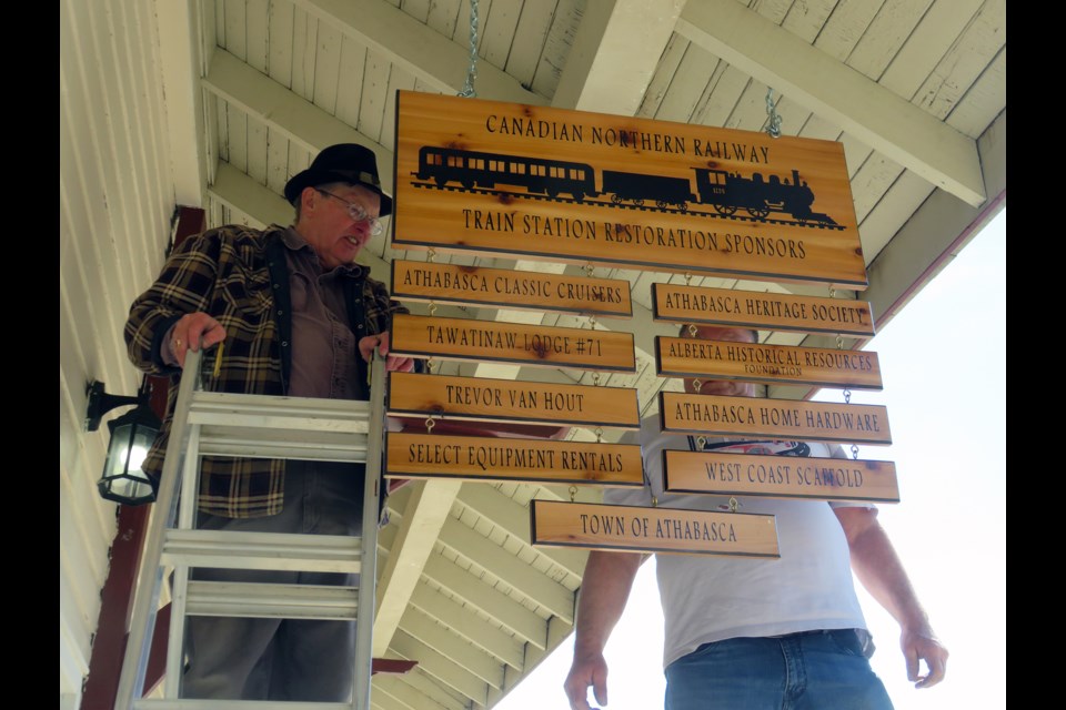 Dan Huber and Cecil Haugen from the Athabasca Classic Cruisers Car Club put up a new crafted sign, created by Diann’s Creations, at the historic CNR train station in Athabasca May 19 to recognize those who have contributed to the restoration of the building over the years. 

Submitted 