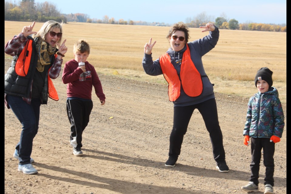 Staff members Karen Kerr and Barb Cholach show some enthusiasm as Gr. 3 student Markus Merrier-Houle and Kindergartener Terrance Skiba make their way north for hotdogs and a rest.