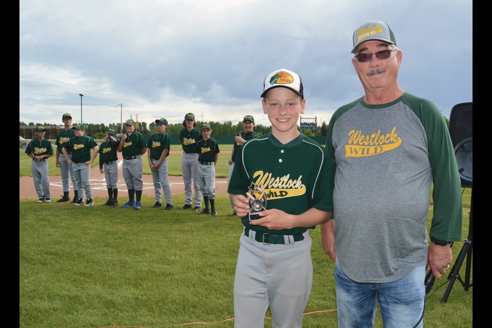 Dayce Madson of the 13U Westlock Wild proudly shows off his heart and hustle award, standing next to coach Les Butler during the Westlock Minor Ball Association awards event June 21 at Keller Field. 