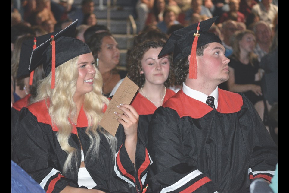 Paytyn McNelly, left, and Ryan Medcke listen to a tribute to teachers and the school board.