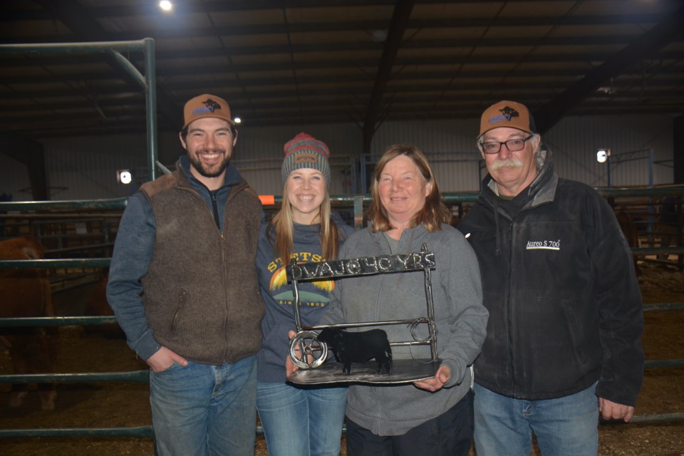 On March 14, Dwajo Angus was presented with a home-made metal sign at the 23rd-annual On Target Bull and Female sale commemorating their 40 years of raising purebred Angus cattle. The sign was made by Dwayne’s brother. L-R: Jesse Emery, his fiance Miranda Pybus, and Dwajo founders Joanne and Dwayne Emery.