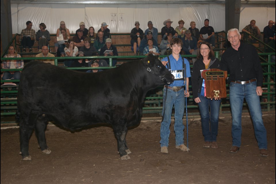 Colton Fenske with his Grand Champion steer KILLER at the 49th-annual Bon Accord 4-H Club beef show and sale was held Wednesday, May 24. Presenting the Farm Credit award is Tammy Round, assisted by Town of Morinville mayor Simon Boersma. 