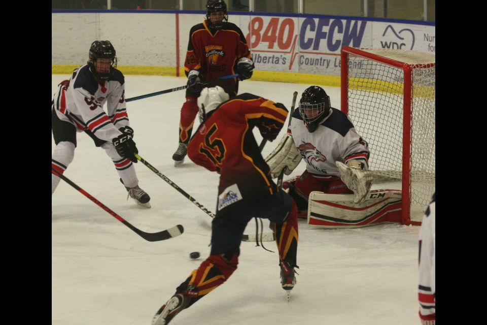 Westlock U18-1 Warriors’ Jackson Rufiange feathers a pass through to teammate Charles Rufiange who deposited the puck in the net during the club’s 5-3 win over the Sturgeon Mustangs in the opening game of the 17th-annual Gord Smith Memorial Tournament played Dec. 9 at Rotary Spirit Centre.
