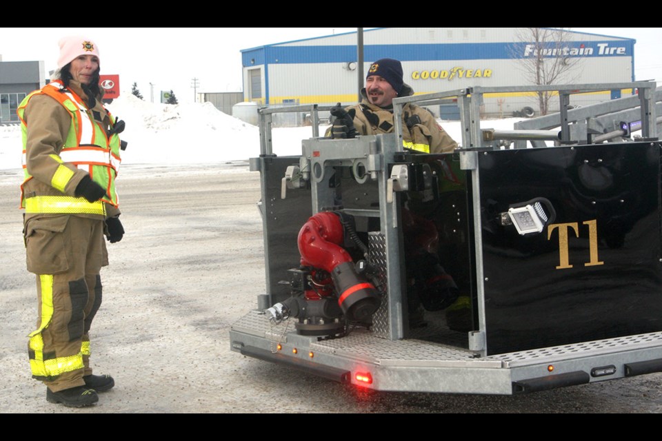 Town of Westlock firefighter Brad Watson gets ready to go up in Tower 1 for the Firefighter in the Sky fundraiser on Dec. 15. With Watson on the ground is firefighter Shauna Biro. Town of Westlock and County of Westlock firefighters have been collecting donations for the Westlock Foodbank as well as the Coats for Kids and Families program by Westlock and District FCSS.
