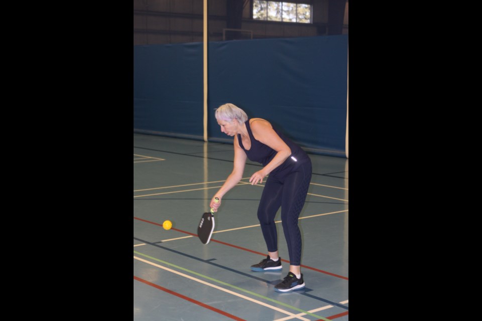 Deneen Bordula returns the ball hit by her husband Darrell during an April 14 match.