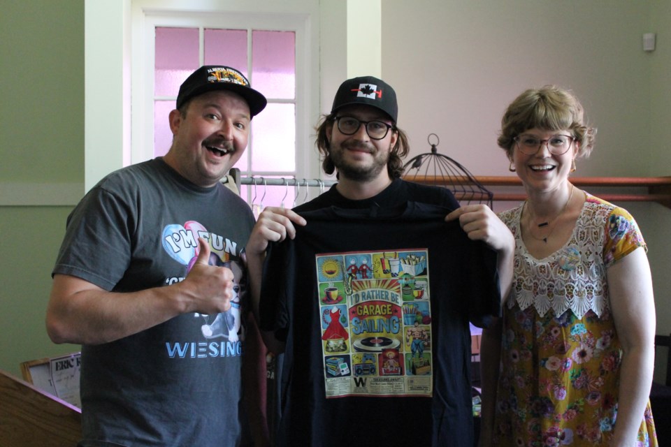 Justin and Chelsey Weisinger gave Mike C. (middle) from Sicke Media a new t-shirt based on the Garage Saling music video shot in Westlock that he filmed. 