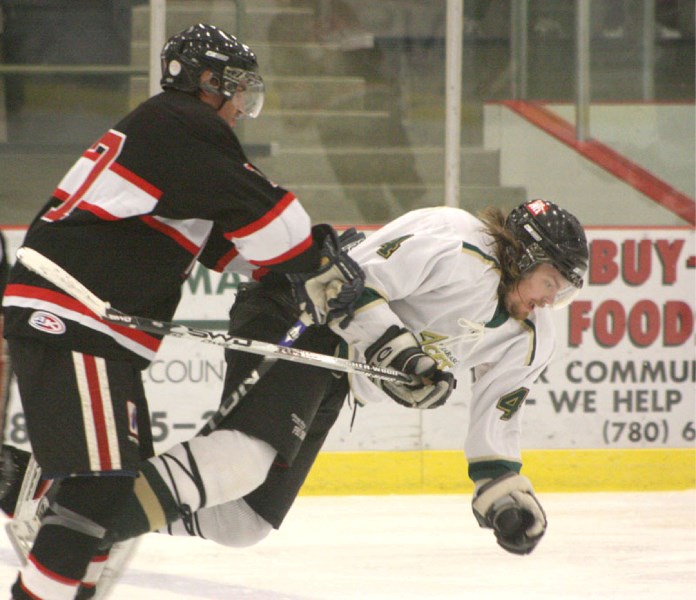 Slave Lake Winterhawk Chad Paulson (l) dumps Athabasca Ace Eric Creaser (r) in the third period of the Aces&#8217; home opener Friday night at the Athabasca Regional