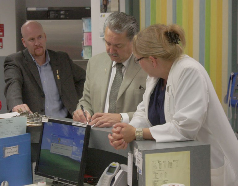 Athabasca-Redwater MLA Jeff Johnson (l) looks on as Alberta Health Minister Gene Zwozdesky discusses hospital conditions with nurse Michelle Taylor at Athabasca Healthcare