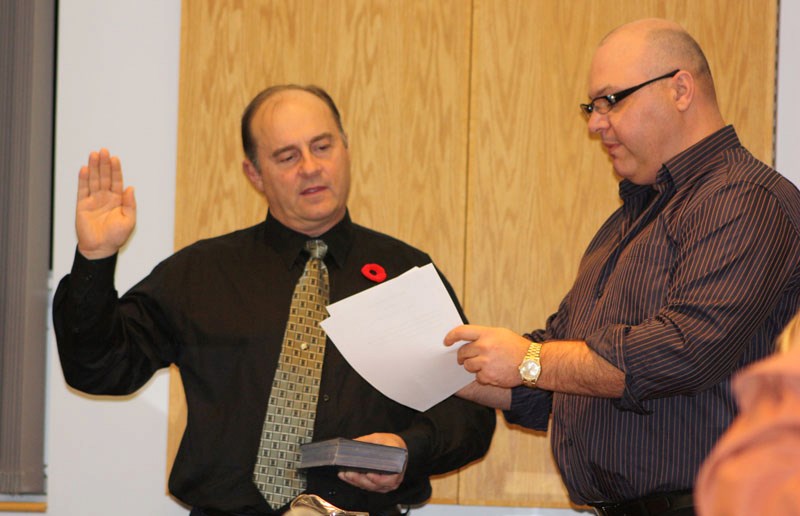 Mayor elect Roger Morrill (l) is sworn in by fellow town councillor Richard Verhaeghe during the organizational meeting on Oct. 28.