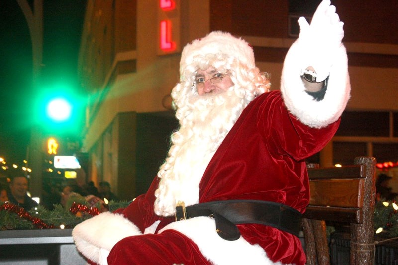 Santa Claus waves to spectators in the Moonlight Madness parade Friday night.