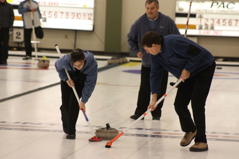 Cheryl and Gary Christensen sweep as Ed Deren looks on during the 2011 Athabasca Mixed Open Bonspiel last weekend. 24 teams took part in the three-day event.