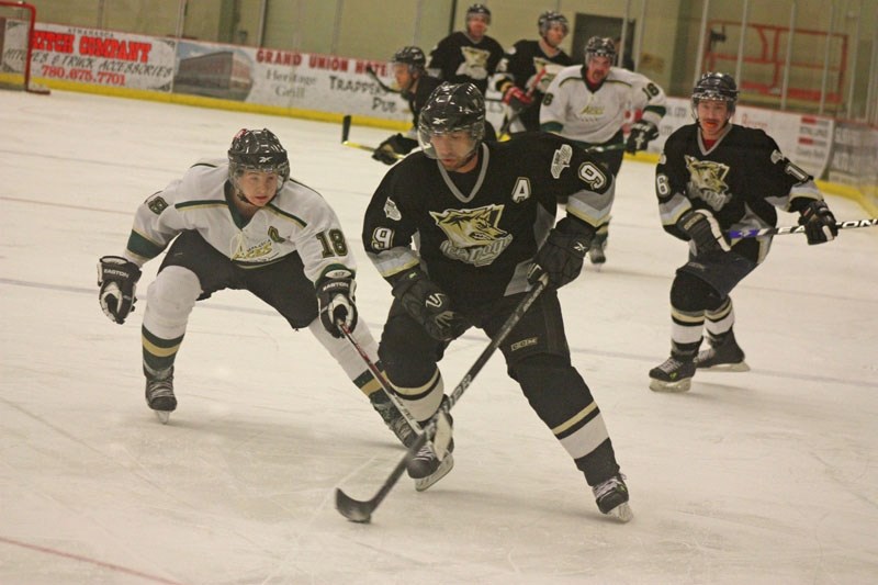 Justin Tebbenham (18) of the Athabasca Aces tries to catch Allan Erick (9) of the Onoway Ice Dogs on Saturday night. The Dogs won 9-1.