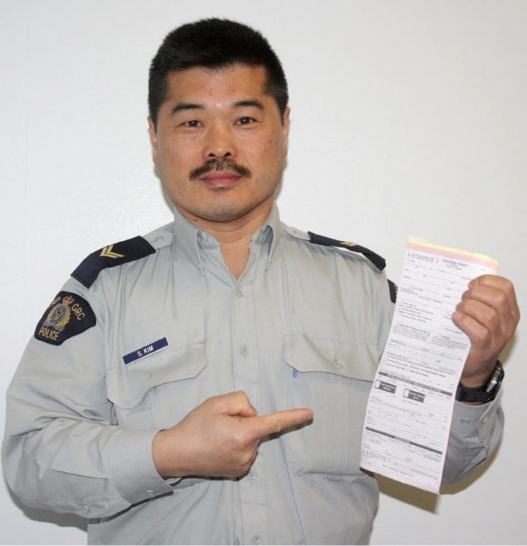 Boyle RCMP Cpl. Sonny Kim holds up a seatbelt ticket, advising motorists to buckle up to stay safe.