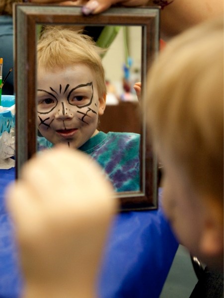 Danniel Ducommun admires his new look after being facially transformed into a mystical character at the Athabasca Wellness Fair and Trade Show on April 30 at the Regional