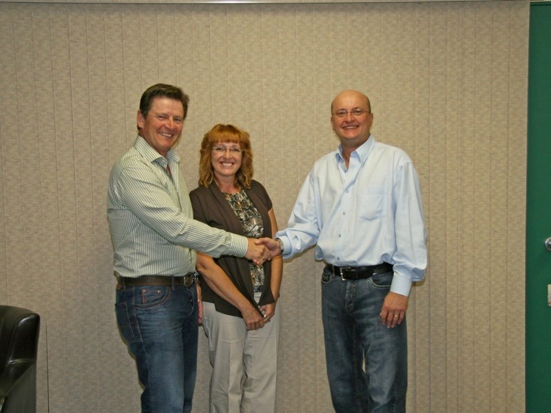County couple Garry and Torresa Szmyrko shake hands with Portage College president Dr. Trent Keough after signing the agreement to donate ten acres of land for the