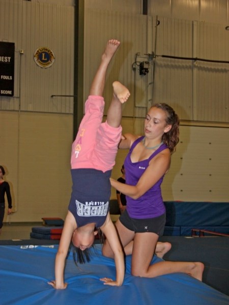 The Athabasca FLIPS Gymnastics Club held a camp for its young athletes at the Athabasca Regional Multiplex last week. Regina Shim works on her back walkover with the help of