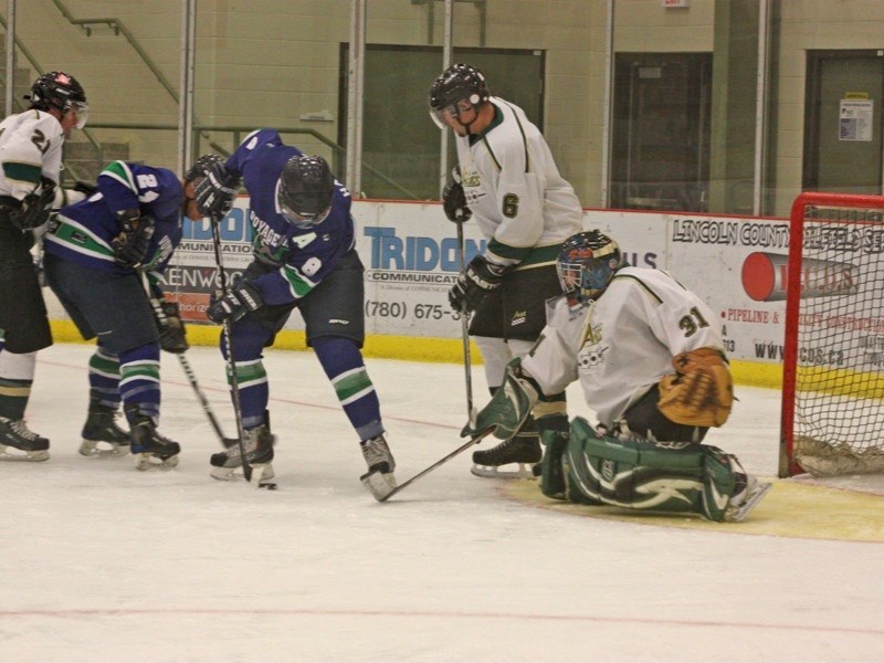 Goaltender Jeff Creaser of the Athabasca Aces defends his crease while members of the Portage College Voyageurs crash the net during an exhibition game at the Multiplex last