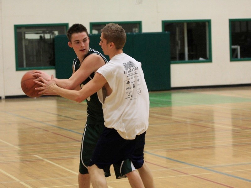 The Edwin Parr Composite senior boys basketball team played an exhibition game against alumni of the program on Dec. 20. Cole Hamilton keeps the ball away from alumni team