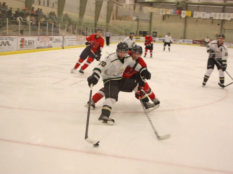 Andy Skoreyko (20) of the Athabasca Aces weaves around a member of the Hinton Heat during game action at the Multiplex on Sunday. The Aces won the game 12-3.