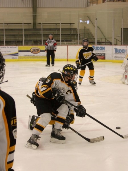 Trenton Tangedal of the Athabasca Peewee &#8216;A&#8217; Hawks battles for the puck during provincial action against Stony Plain on Sunday. The Hawks won 5-4.