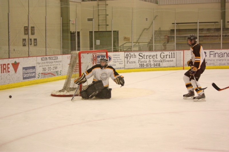 Robbie Mason of the Athabasca Midget &#8216;A&#8217; Hawks kicks the puck away during the team&#8217;s 5-1 playoff win on Saturday.