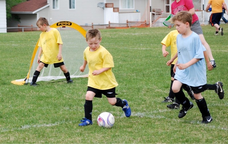 U8 player Seth White of the Athabasca Lightning takes the ball and races down the field as teammates and opponents follow during soccer action on the weekend.