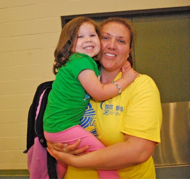 Jayden Allen, 3, hugs her mom Nicole Allen, a cancer survivor, at the Athabasca Relay For Life on June 15. The 12-hour walk to help raise money and awareness for cancer