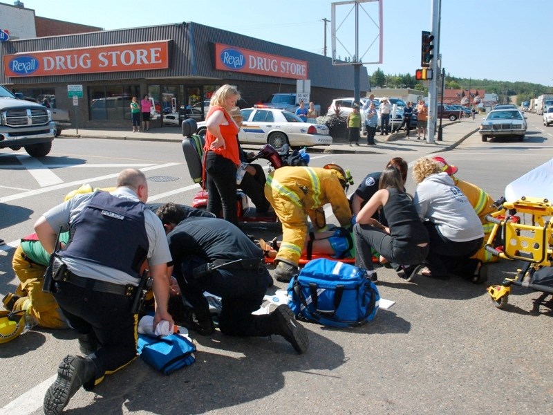 A mother and daughter were hit by a pick-up truck while crossing the street on Aug. 28. Emergency crews work on the women at the scene prior to transporting them to the