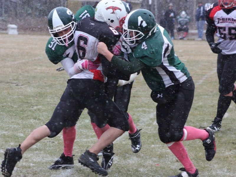 Randall Weber (31) and Justin Kwasney (4) of the Athabasca Pacers team up to take down an R.F. Staples ball carrier during their playoff game at Edwin Parr Composite on