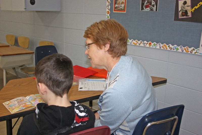 Linda Roberts helps a student read at LTIS.